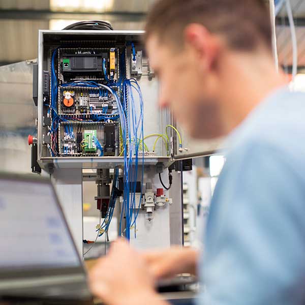 Male Engineer In Factory Using Laptop Computer